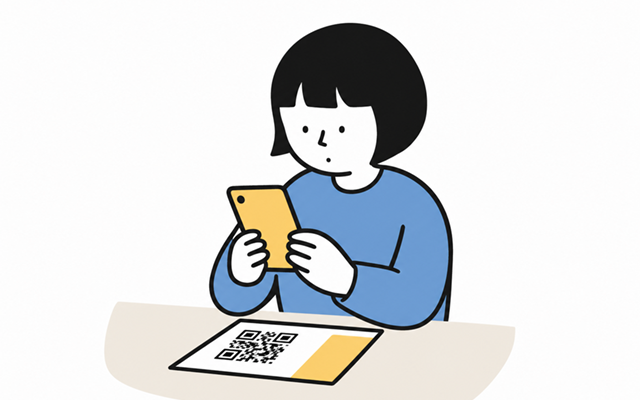 チラシの二次元コードをスマホで読み取っている
